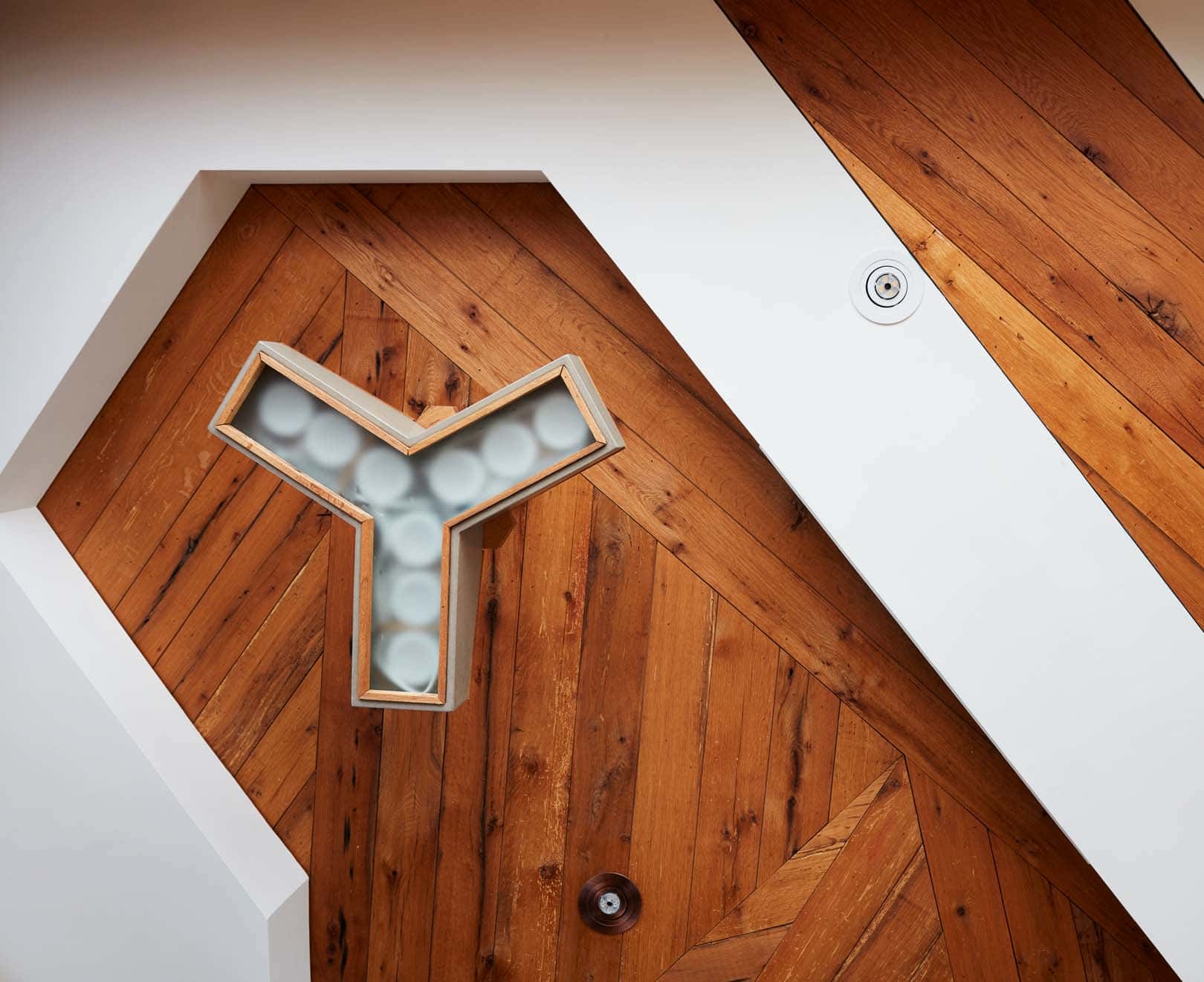 Close-up details of the custom architectural lighting and sustainable wood design at The Kinsman, illustrating the modern craftsmanship of our NYC grooming salon.